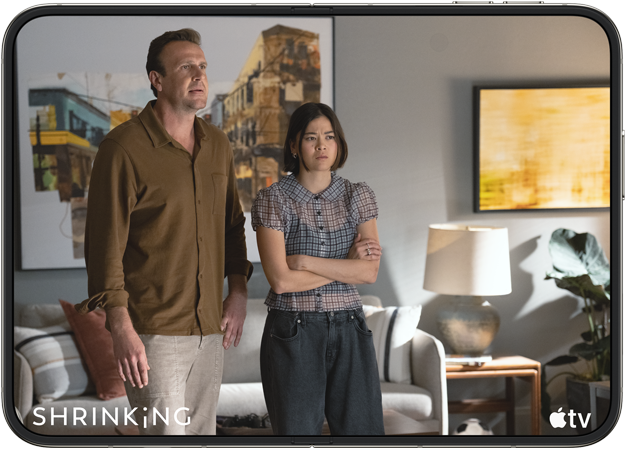 Two people standing thoughtfully and tense in a modern living room with artwork and lighting