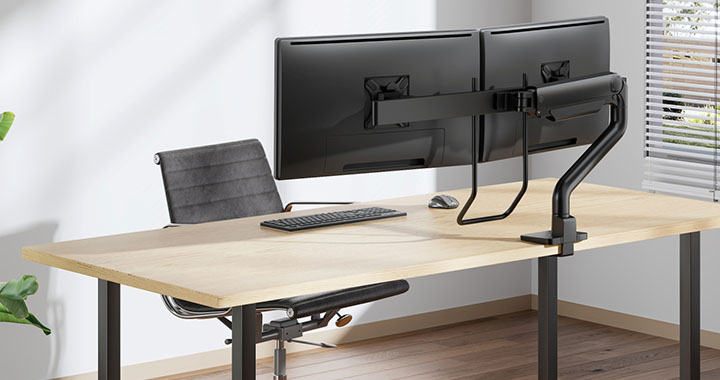 Modern workspace with two monitors on adjustable mount and ergonomic office chair in bright office setting