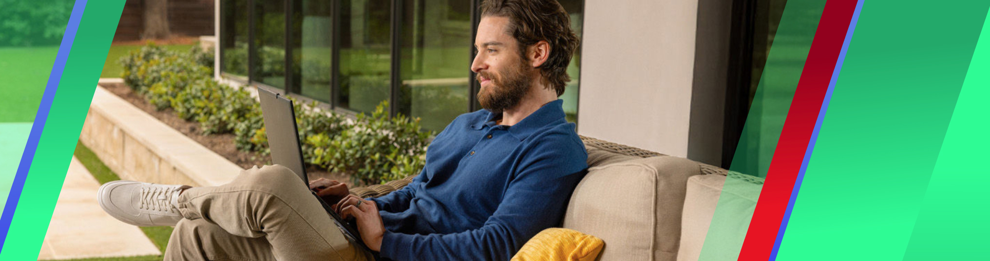 Men sitting outdoor on a cosy lounge with a laptop on his legs.