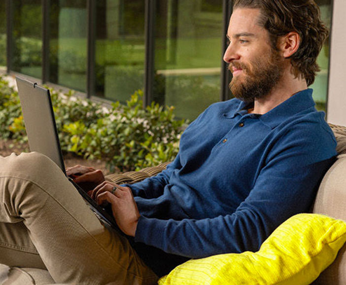 Man sitting on a lounge working on a laptop