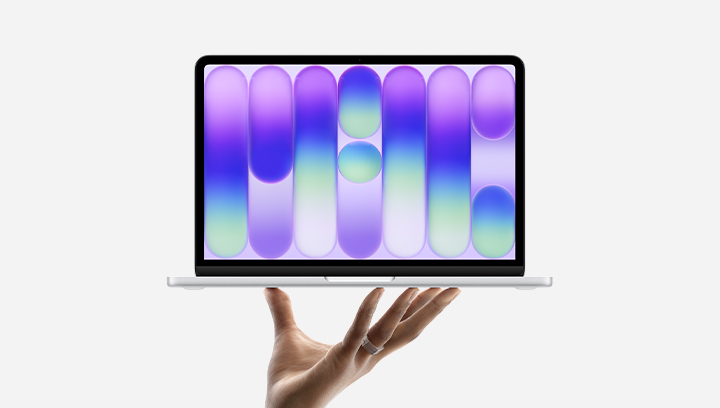 Apple MacBook Neo. A hand holds up the new MacBook Neo in silver.